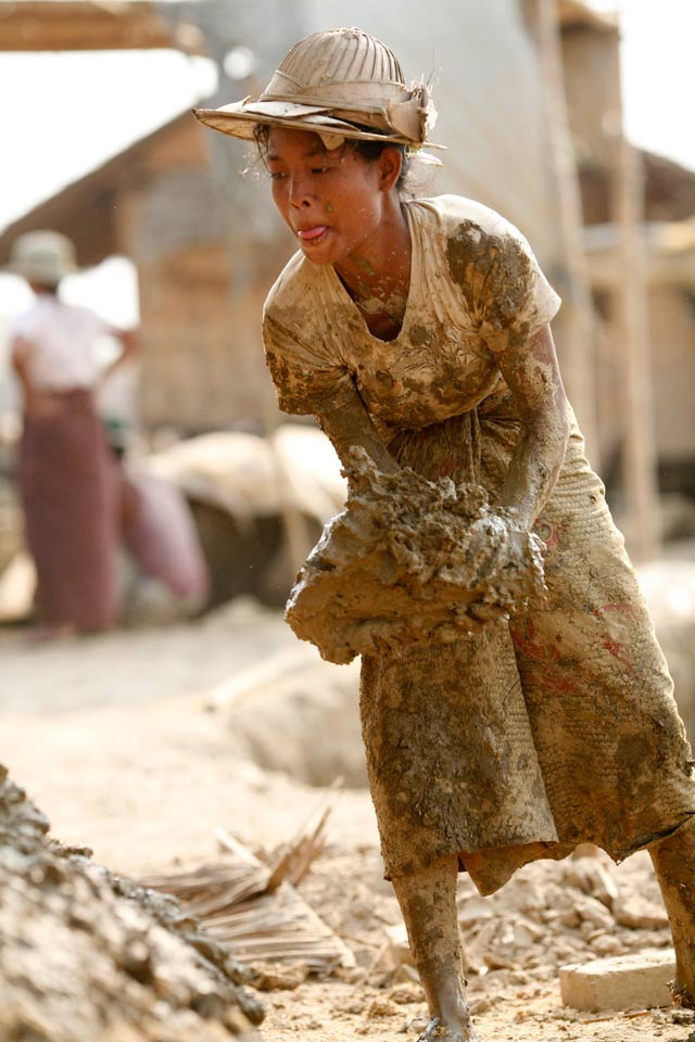 Photo: Soe Zeya Tuny/Reuters Dirty jobs: a woman carries mud to shape into bricks at a kiln near Hlawga village, north of Yangon.