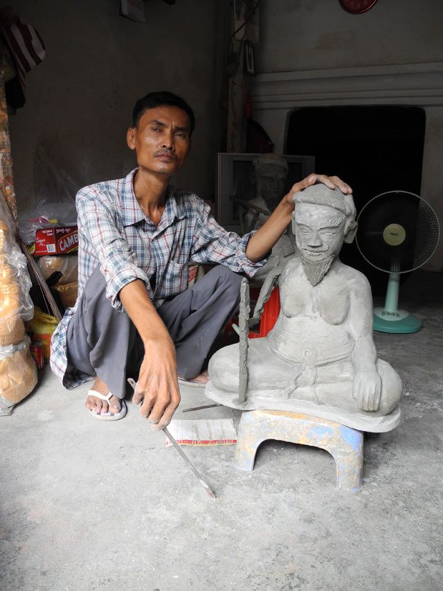 Sok Dul showing off one of his best-selling Buddhist statues