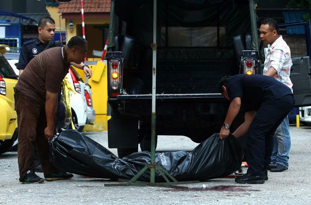 Spilling blood: the body of Arab-Malaysian Development Bank founder Ahmad Najidi is removed by forensic police in Kuala Lumpur