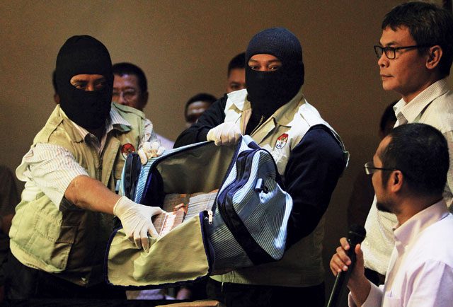 In the bag: Indonesian anti-corruption investigators display the alleged bribe money seized from chief justice Akil Mochtar’s home in Jakarta. AFP