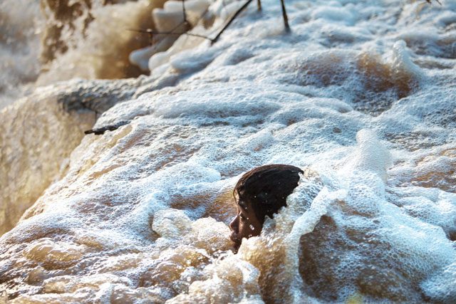 A man checks a trap near the Don Sahong dam site