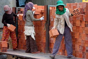 Stacking up: workers lug bricks around one of Phnom Penh’s many construction sites. Photo: EPA/Mak Remissa