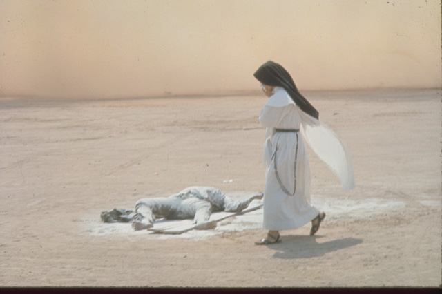 A nun passes the body of a North Vietnamese soldier killed in action outside a Catholic Church at Dong Lach (Vietnam, 1969). Photo: Tim Page