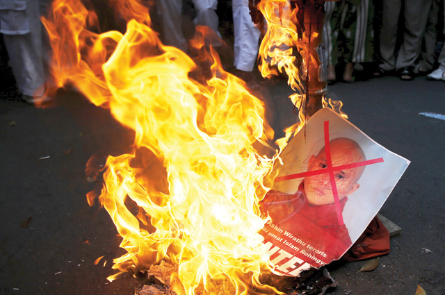 Under fire: members of Indonesia’s Islamic Defenders Front burn Wirathu’s image