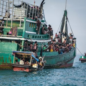 Home and away: Acehnese fishermen help Rohingya migrants into their boat off the coast of Kuala Simpang Tiga. Photo: AFP