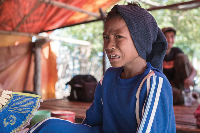 Nine-year-old jockey Farhan cries as his sister treats his wounded leg. Photo by Putu Sayoga