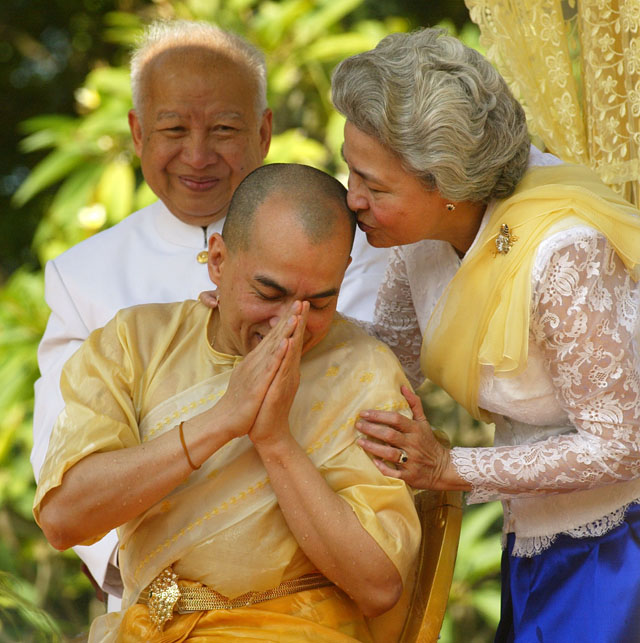 Cambodia's new King Norodom Sihamoni (C) is kissed by his mother Queen Norodom Monineath (R) while his father, former King Norodom Sihanouk looks on during a religious ceremony at the Royal Palace in Phnom Penh, 29 October 2004. Traditional religious rituals for the coronation of new Cambodian monarch continues for the second day as his ascension to the throne nears. AFP PHOTO / Jimin LAI