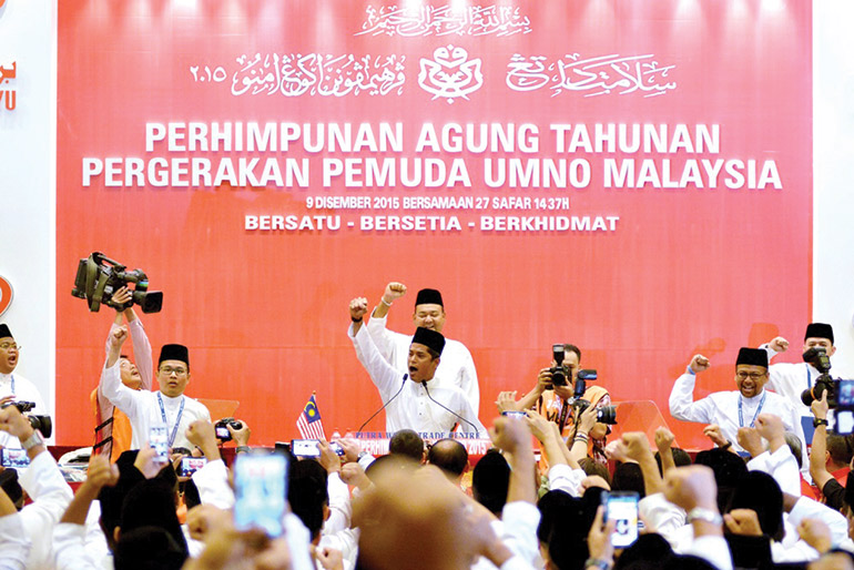 Khairy Jamaluddin leads delegates in a chant at the UMNO Youth general assembly