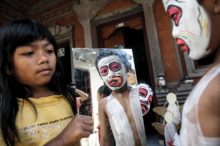 A Balinese boy checks his appearance before the parade begins