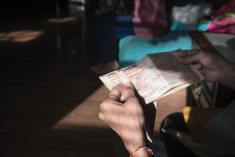 Sokhoeurn Kol, 60, looks at her old plane ticket to the US. After spending years in a refugee camp, Sokhoeurn and her family arrived in the US on 5 December 1984