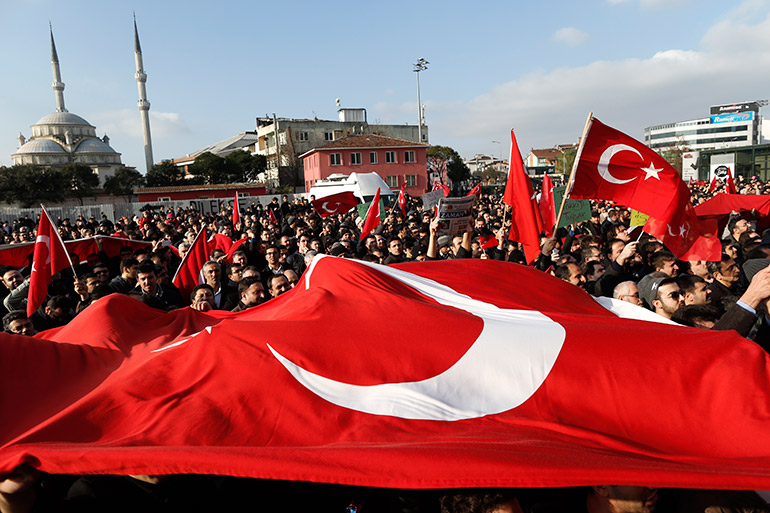 Supporters of Fethullah Gulen Movement shout slogans as they wave Turkish flags outside a courthouse after Turkish police began an operation targeting the media close to the Fethullah Gülen, in Istanbul, Turkey