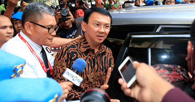 Jakarta Governor Basuki Tjahaja 'Ahok' Purnama (C) talks to journalists shortly after investigation by the police in Jakarta