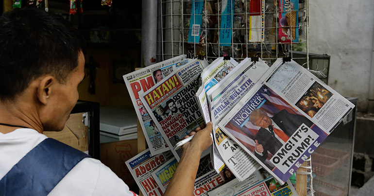 A man in Manila looks at newspapers announcing the election of Donald Trump as president of the US, 10 November 2016.