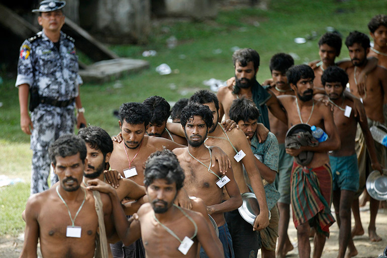 Rohingya men who were found at sea line up in Rakhine state to board a truck to a refugee camp in Bangladesh