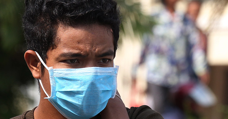 A Cambodian man wears a mask as he walks at the Khmer-Soviet Friendship Hospital in Phnom Penh, Cambodia, 24 February 2016.