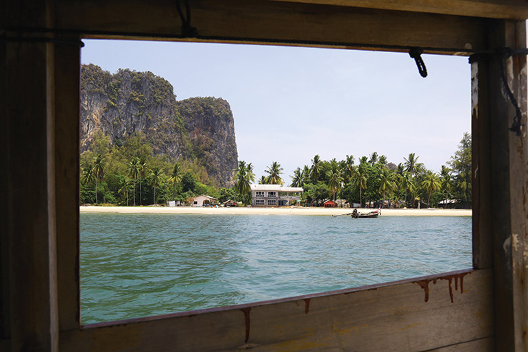 a view of the Thai coast through a longtail window as the boat comes in to dock after visiting the Trang islands