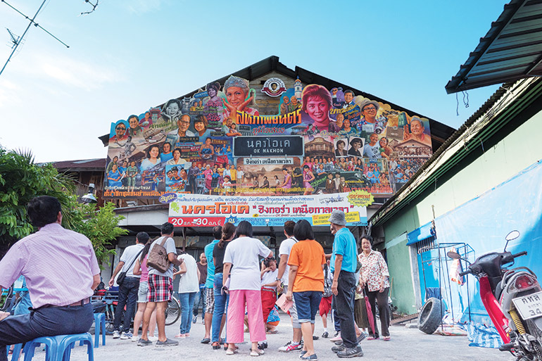 Artistic visions: residents of Songkhla’s old town, in the south of Thailand, admire the cinema billboard created by artist Navin Rawanchaikul. Photo: Navin Production