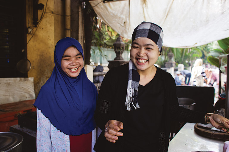 a pair of Cham women show off competing styles of headwear in central Phnom Penh