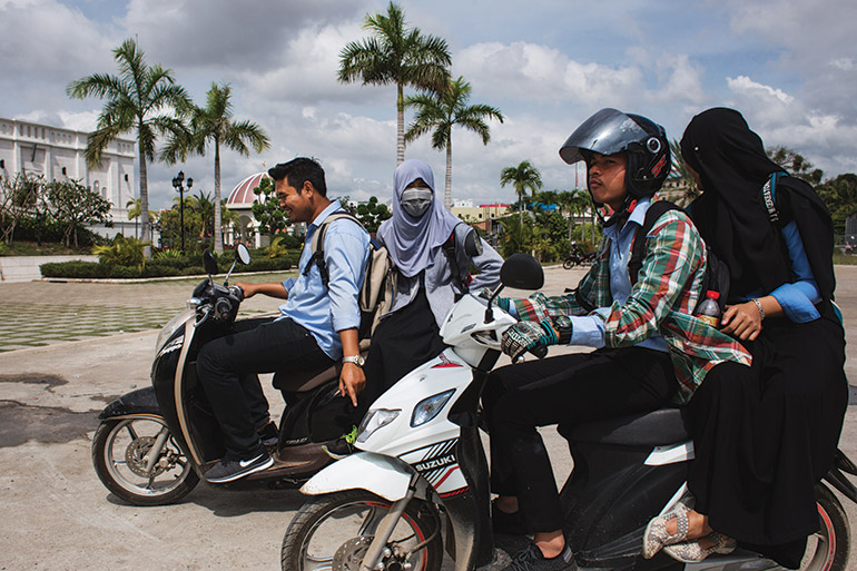 a quartet of young Muslims zip around Cambodia’s capital city on motorised scooters