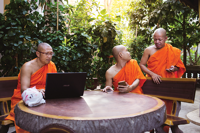 A group of monks in Phnom Penh make use of modern technology