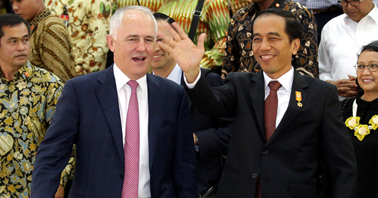 Australian Prime Minister Malcolm Turnbull (L) and Indonesian President Joko Widodo (R) greet the crowd during a visit to the Tanah Abang market in Jakarta, Indonesia