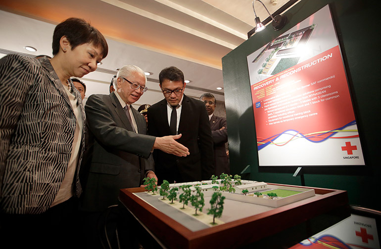 Singapore President Tony Tan Keng Yam (2-R) gestures in front of 'Recovery and Reconstruction' model of a school building with Grace Fu (L) Singapore Second Minister for Foreign Affairs, during the Memorandum of understanding signing and Check turnover ceremony at a hotel in Makati City, south of Manila, Philippines, 04 April 2014. Photo: EPA/RITCHIE B. TONGO