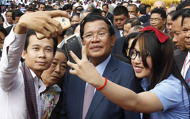 Cambodian Prime Minister Hun Sen strikes a pose with some of his supporters