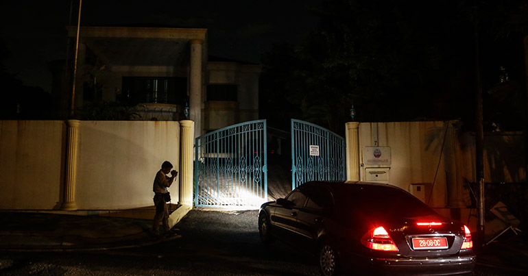 A member of the media (L) records a video as a North Korean official's car enters the North Korea embassy in Kuala Lumpur, Malaysia