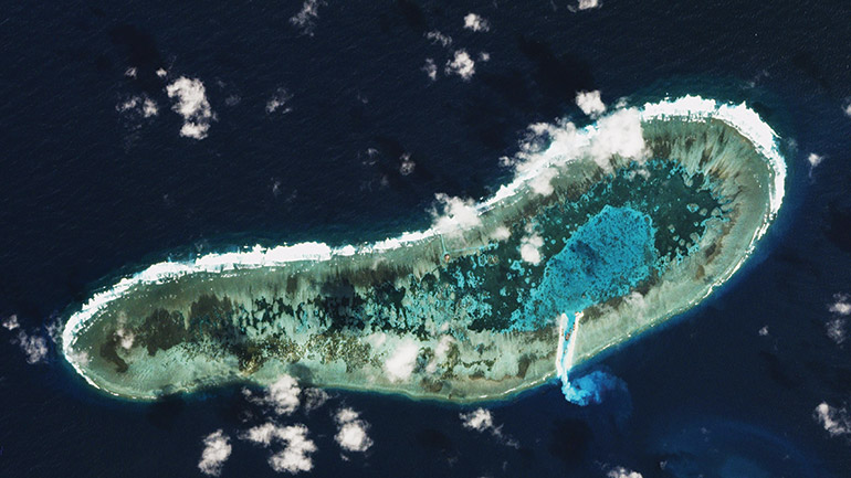 Sand spilling from a newly dredged channel of Vietnamese-held Ladd Reef in the South China Sea's Spratly Islands