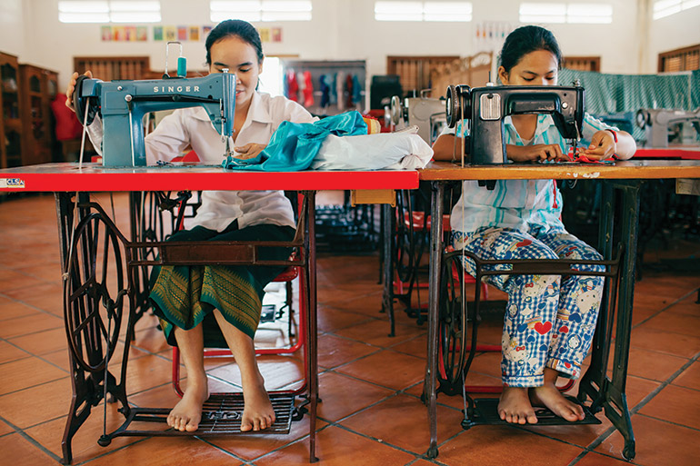 Women sew garments during a lesson at AFESIP’s Phnom Penh rescue centre. Photo: Bernardo Salce