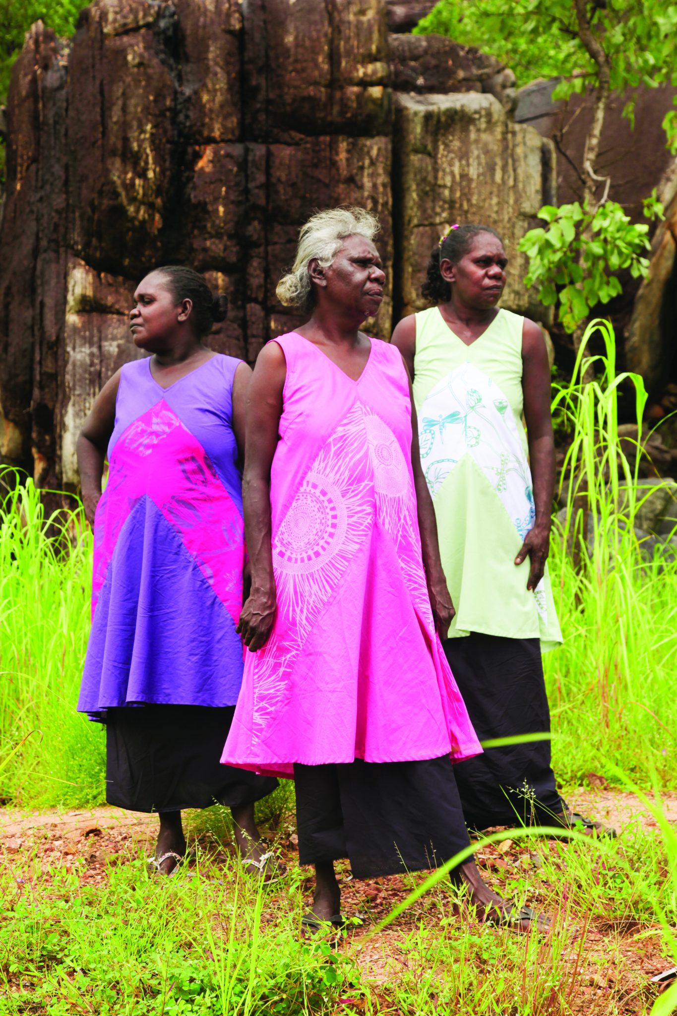 Injalak artists Gwenyth Mangiru, Priscilla Badari and Sylvia Badari wearing the Cambodian-made dresses in Arnhem Land. Photo: Mark Roy