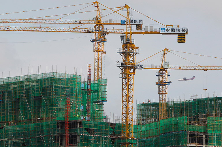 A plane flies over a construction site in Phnom Penh, Cambodia, 10 April 2017. Cambodia's economy is estimated to grow by 7.1% in 2017 and 2018, according to the Asian Development Bank (ADB). Photo: EPA/Kith Serey