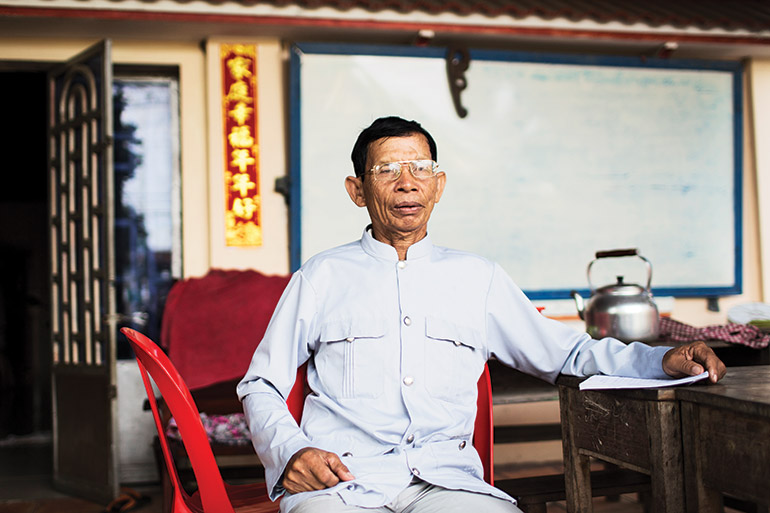 Sin San speaks outside his home in Takeo province’s capital city. Photo: Southeast Asia Globe/Emil Kastrup