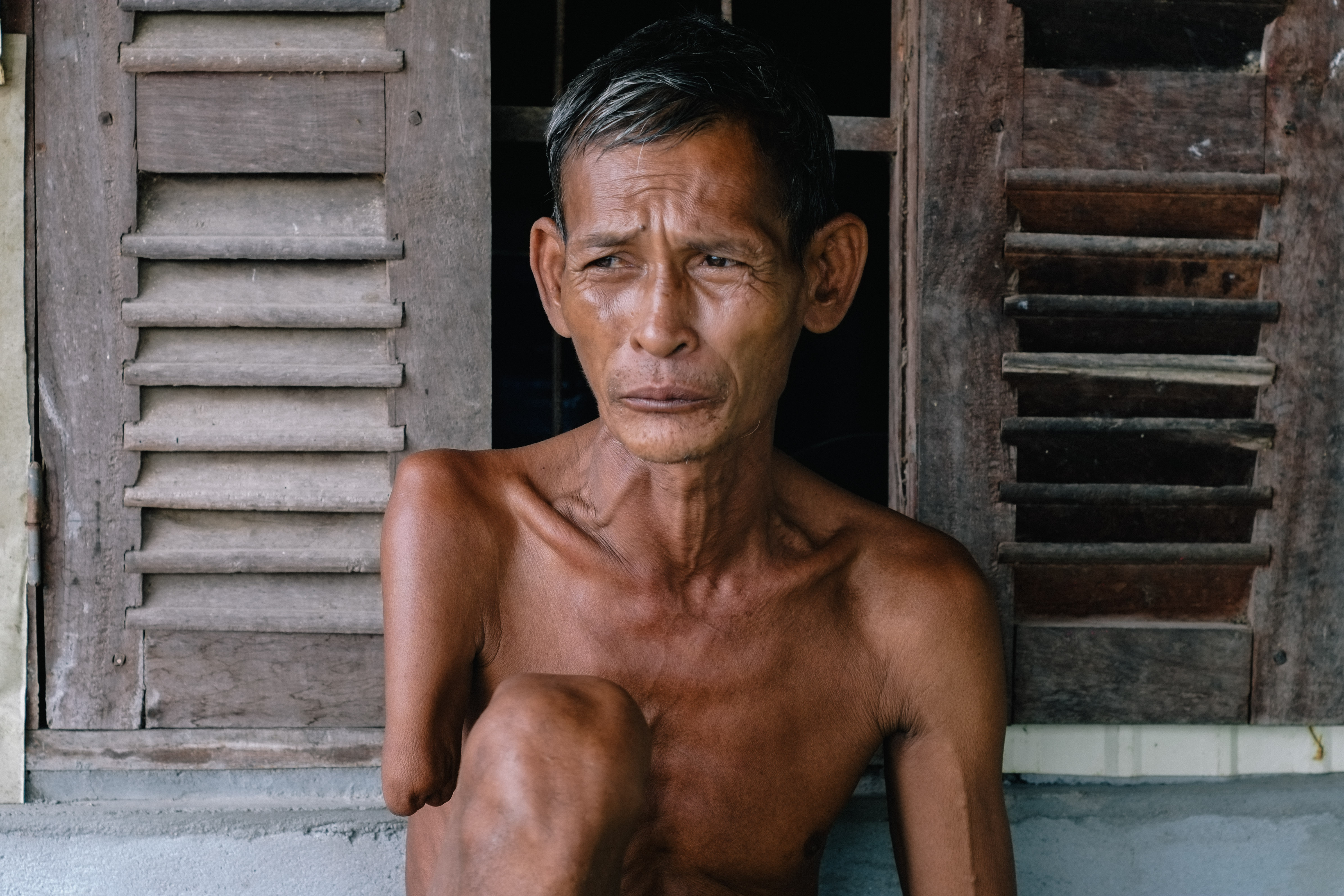 Sophea's father Seurn outside his one-room house in Kampot province, Cambodia. Photo: Lesly Lotha