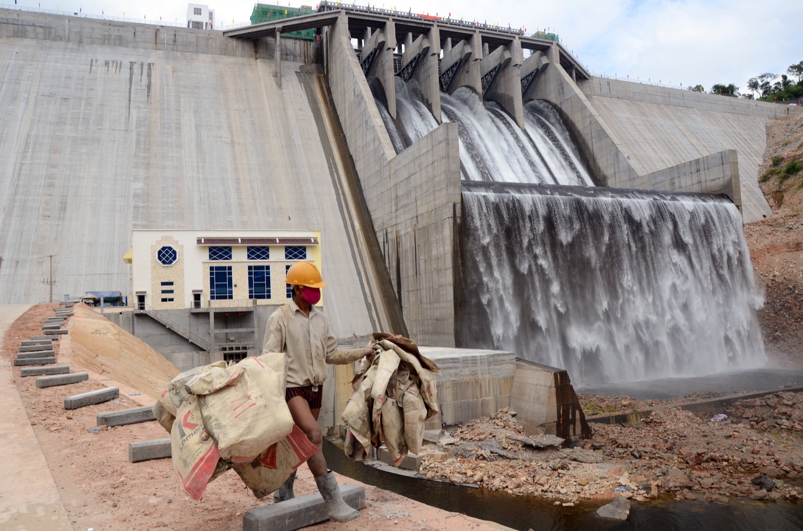 A Cambodian man carries empty cement bags in front of the Kamchay dam during the inauguration ceremony for the Kamchay hydropower dam in Kampot province, some 160 kilometers southwest of Phnom Penh. Photo: Stringer/AFP