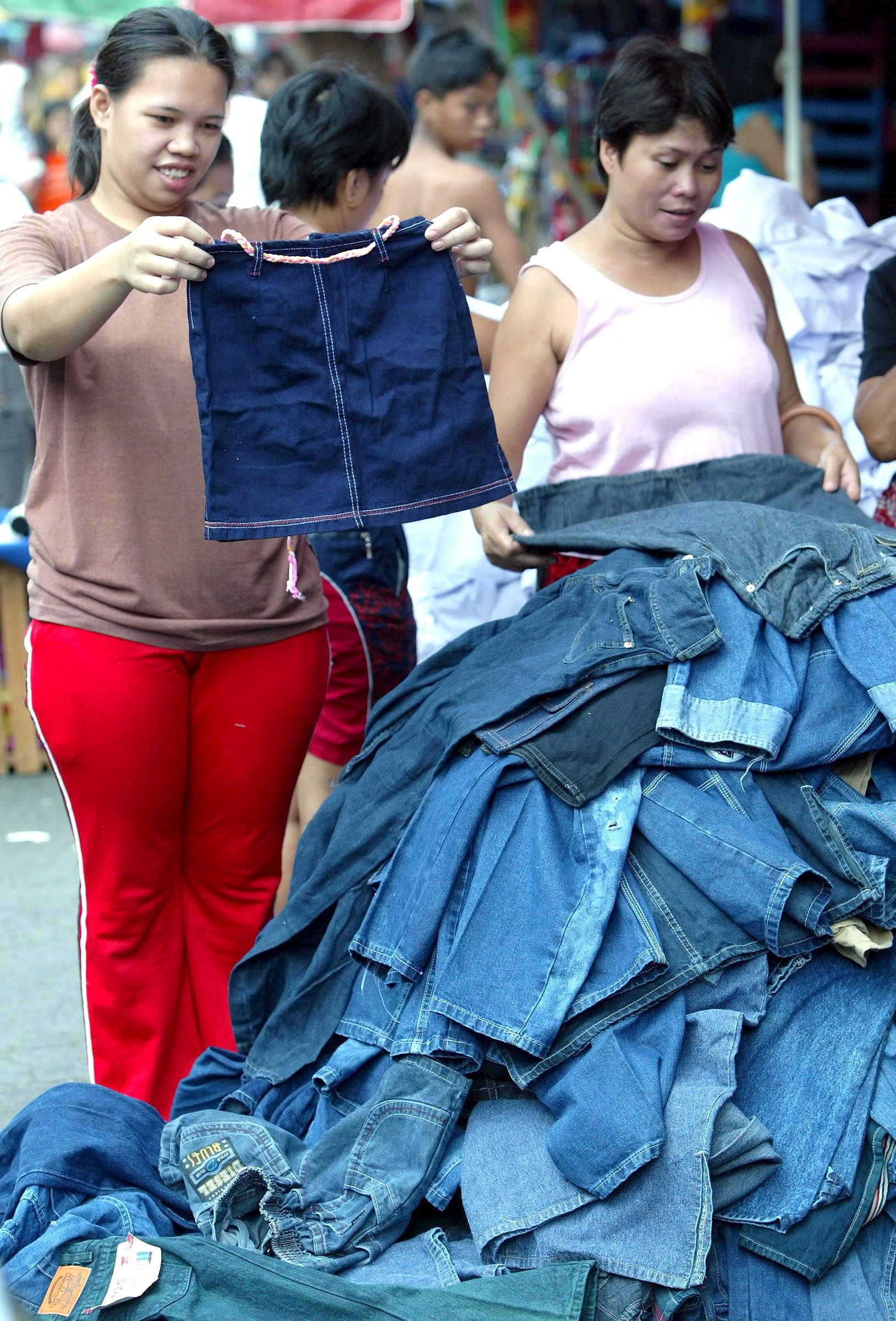 A Filipino consumer chooses from a pile of clothes on sale at a public market in Manila, Philippines. Photo: Rolex Dela Pena / EPA