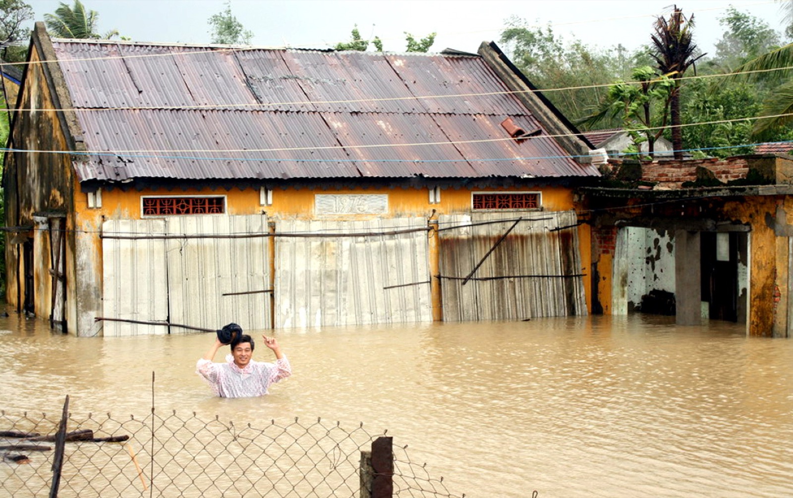 A man walks through flood waters in Tuy An town, Phu Yen Province, Vietnam. Streets in several towns were reportedly submerged in 1.5 to 2 metres of water after rivers overflowed their banks.  Photo: EPA/The Lap