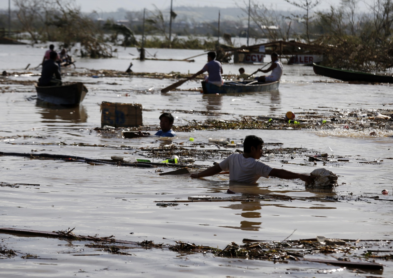 Filipino villagers wade through floodwater at a community that was hit by Super Typhoon Haima in Tuguegarao city. Photo: Francis R. Malasig / EPA