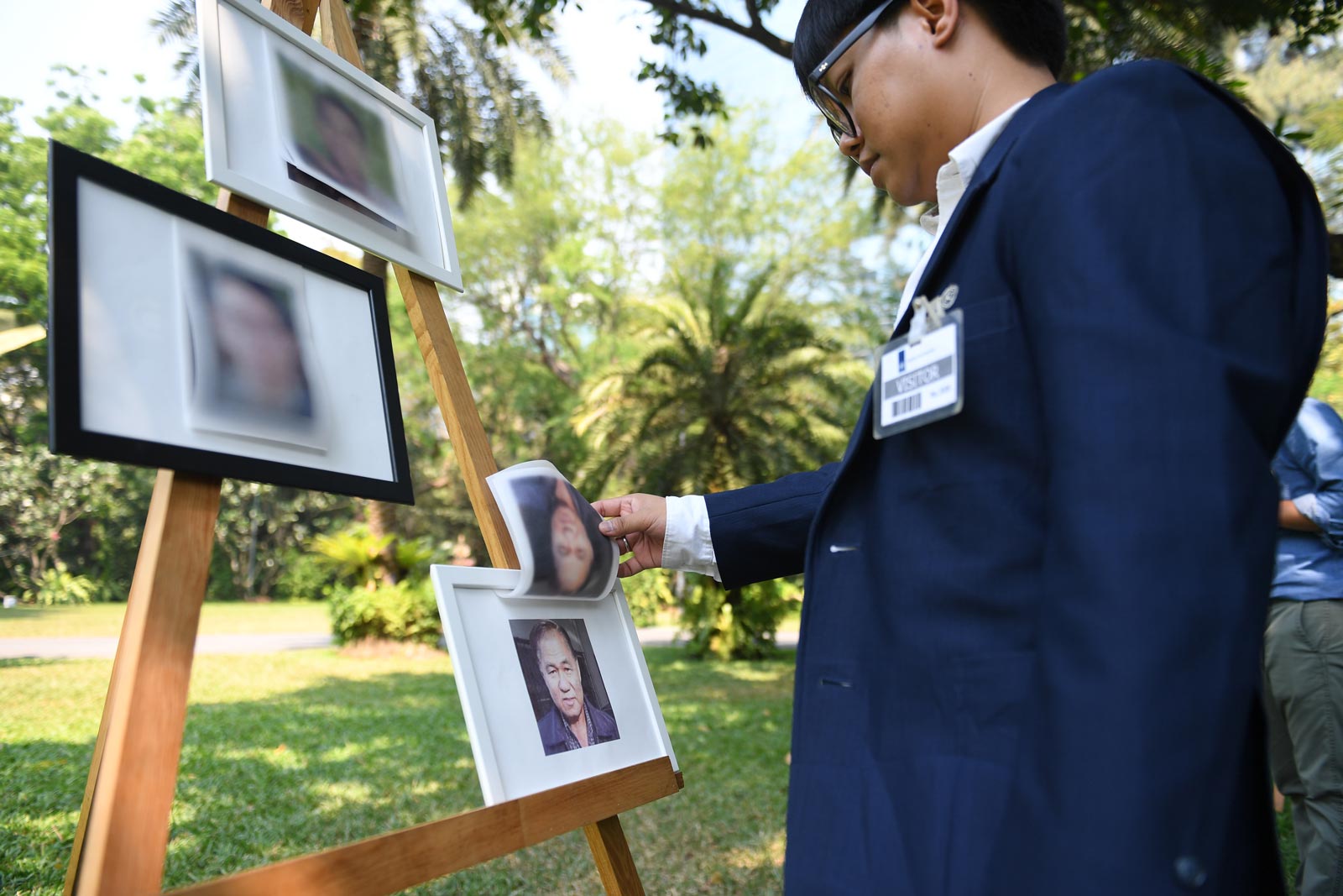 A visitor looking at the  portrait of missing Thai activist Surachai Danwattananusorn displayed during a human rights forum at the Netherlands Embassy in Bangkok. Photo: Lillian Suwanrumpha/AFP.