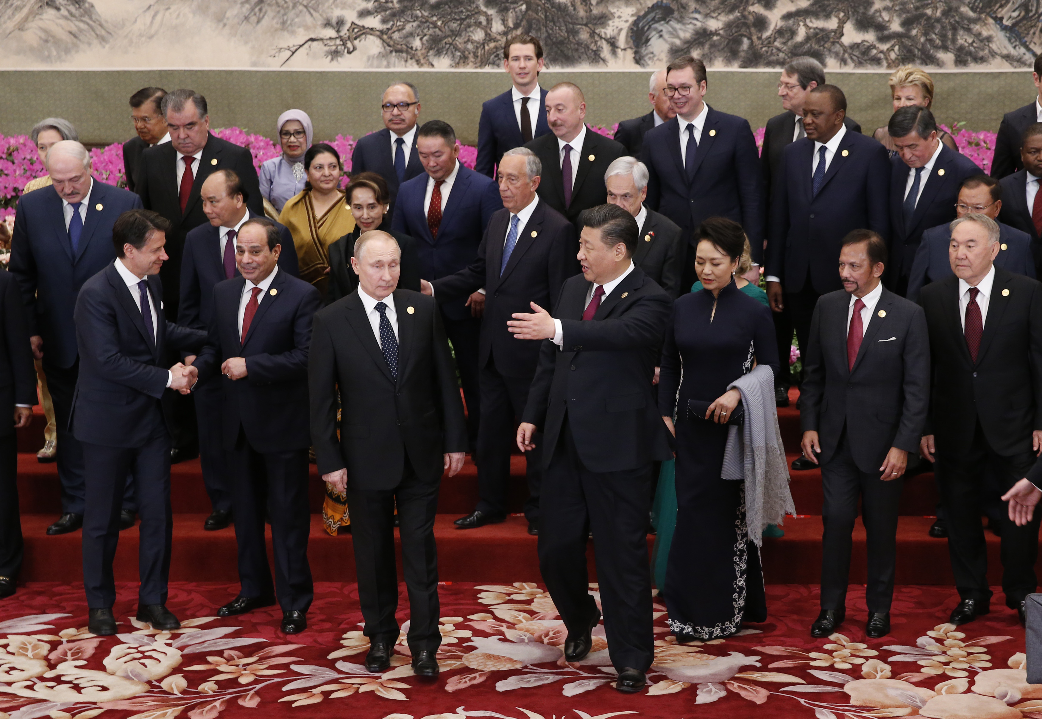 China's President Xi Jinping (C) gestures to Russia's President Vladimir Putin (centre L) after a group photo session at a welcoming banquet for the Belt and Road Forum at the Great Hall of the People in Beijing on April 26, 2019. (Photo by JASON LEE / POOL / AFP)