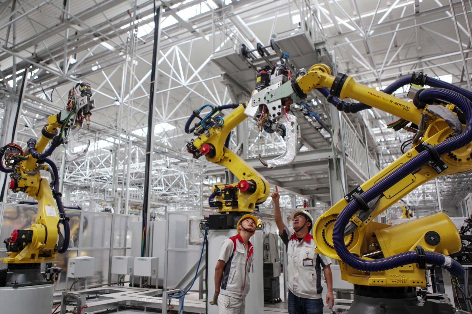 This photo taken on June 12, 2019 shows employees checking equipments at a Great Wall Motors factory in China's southwestern Chongqing. STR / AFP