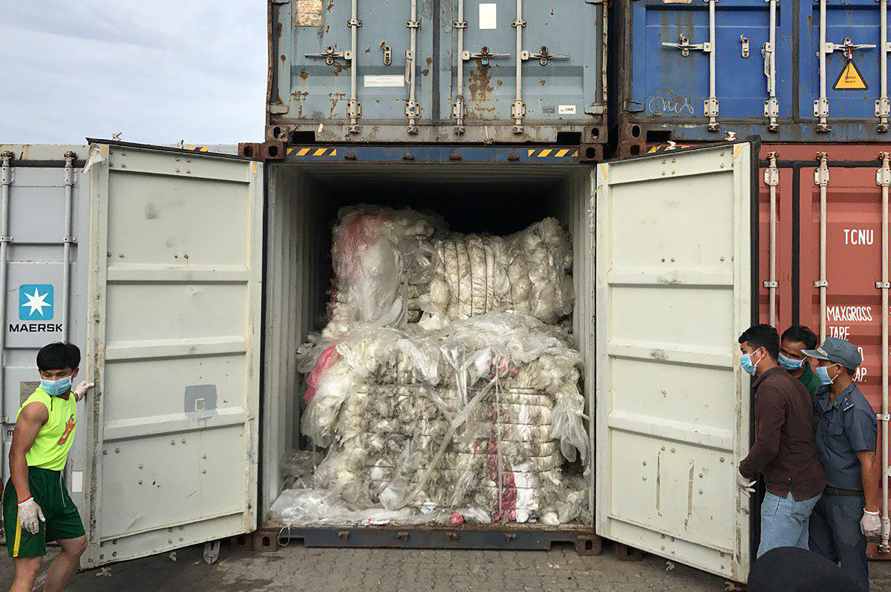 his handout photo taken on July 16, 2019 and released on July 17, 2019 by the Cambodian Ministry of Environment shows workers openinng a container loaded with plastic waste after the shipment arrived at Sihanoukville port in Preah Sihanouk province. - Cambodia will return about 1,600 tonnes of plastic waste to US and Canada after the rubbish were found at a seaport, an official said on July 17