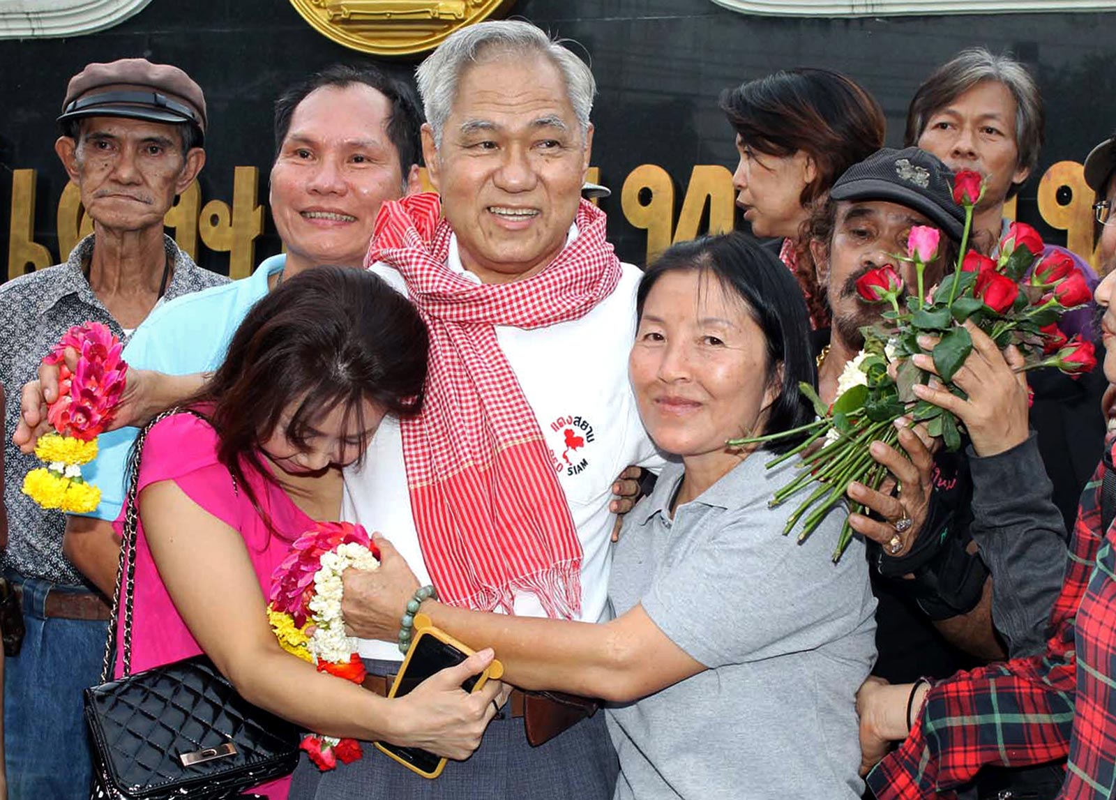 Thai political activist, Surachai Danwattananusorn, 71, (C) is hugged by  his family after his release at Bangkok Prison in Bangkok on October 4, 2013. Photo: AFP