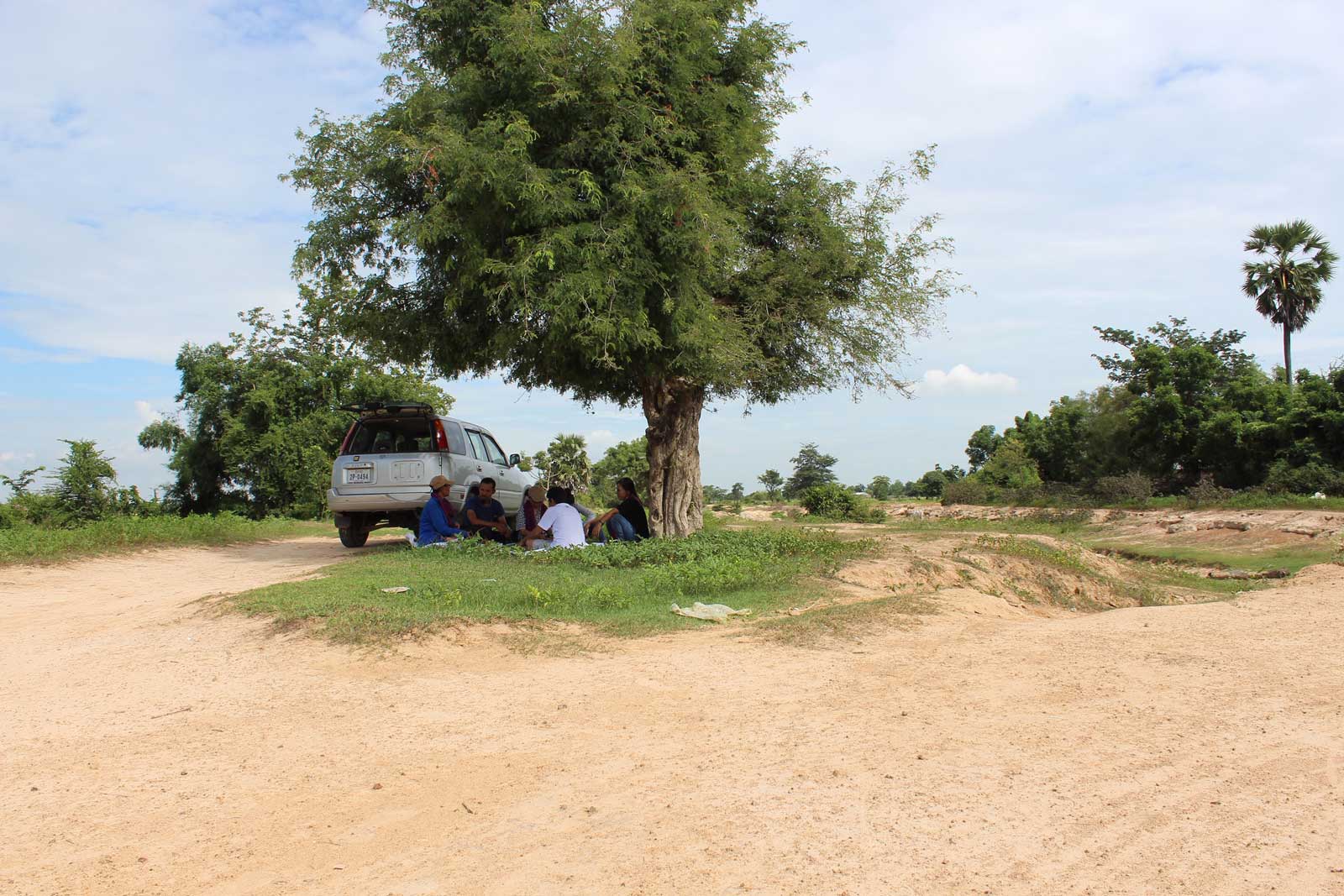 Sitha and Man share their Khmer Rouge experiences with CamAsean activists next to the canal, right, they dug during the regime. This is where Sitha says this was the hardest place to revisit: where the Khmer Rouge separated his and another hundred families into different villages. Photo: Tabitha Payne