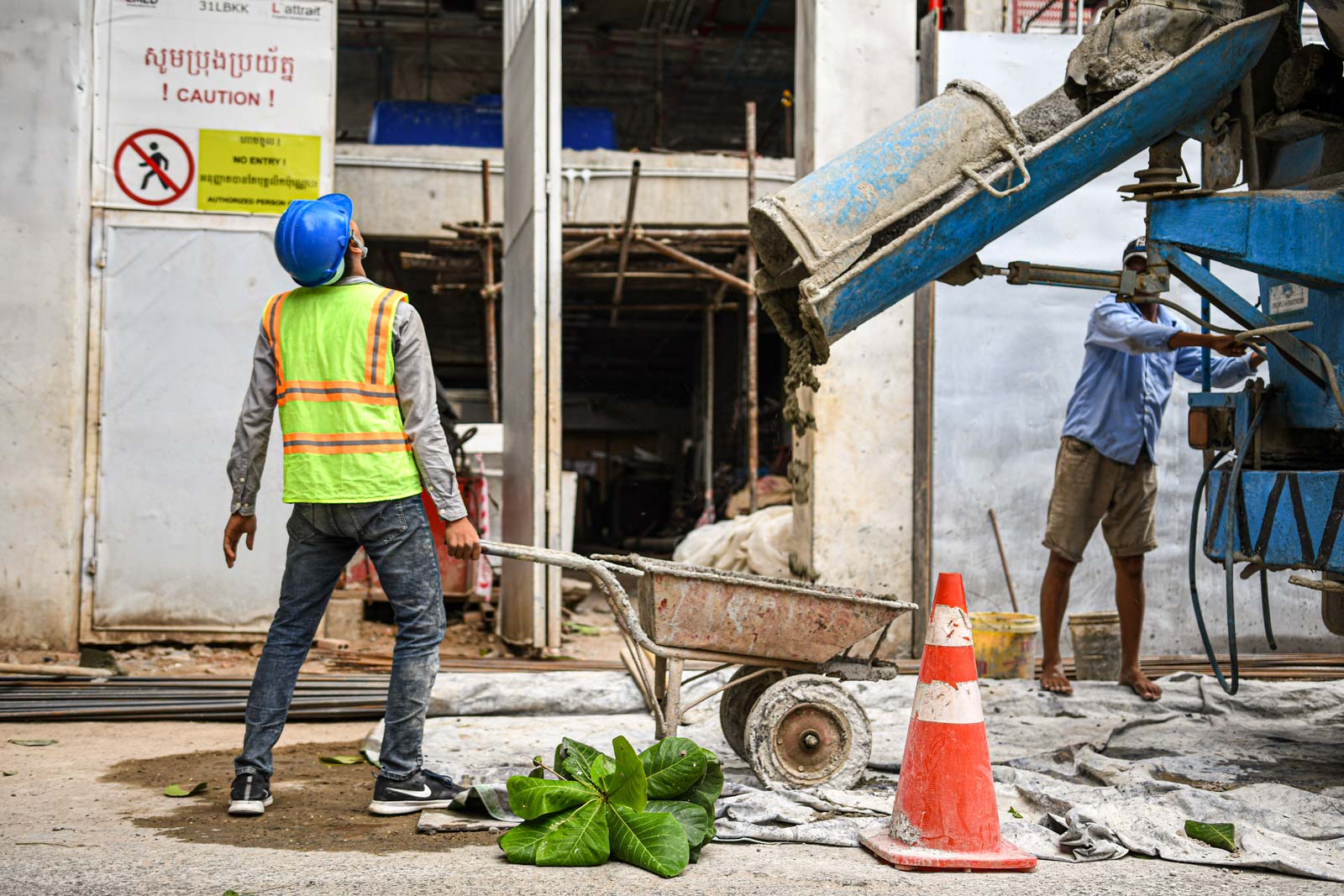 Construction workers in Phnom Penh fetch a barrowload of concrete from a mixer lorry. Photo: Simon Roughneen