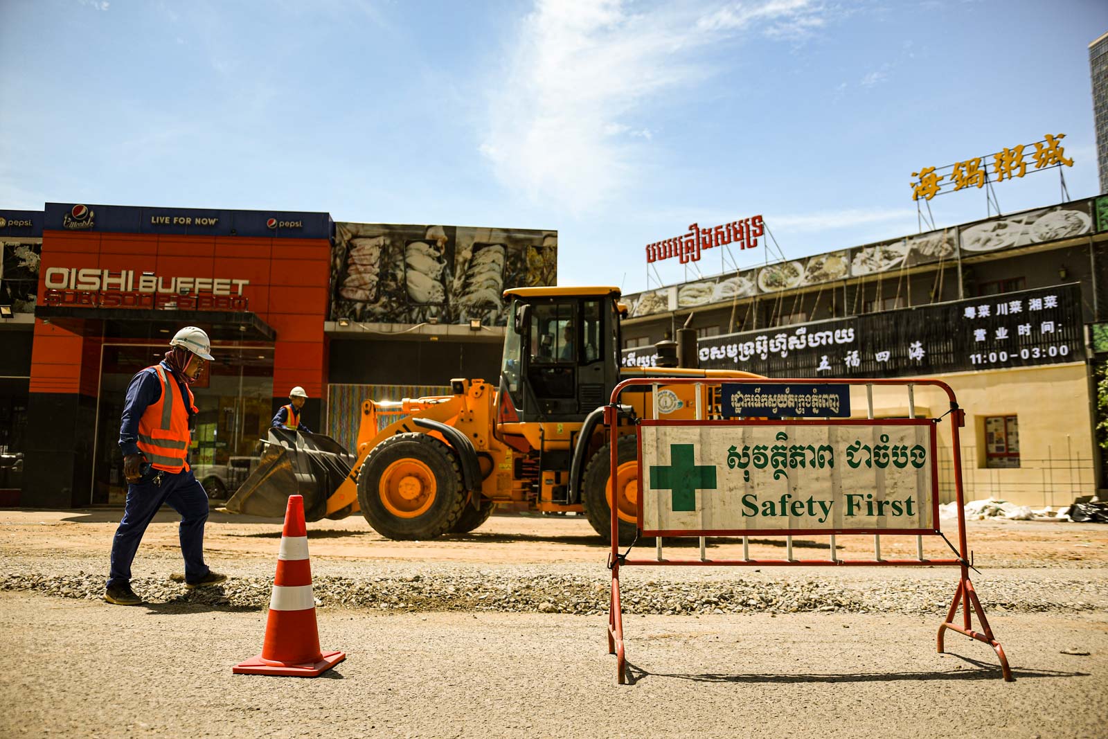 Despite a stifling, blinding midday sun, construction workers at Phnom Penh's better-managed sites must nonetheless don protective gear. Photo: Simon Roughneen