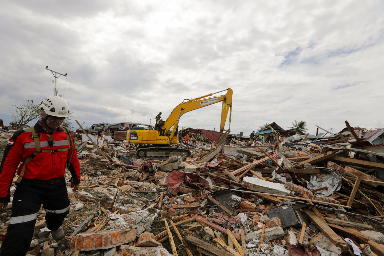 Rescue team use an excavator to search for bodies in the ruins of a house at Balaroa village in Palu in October 2018. EPA-EFE/Hotli Simanjuntak