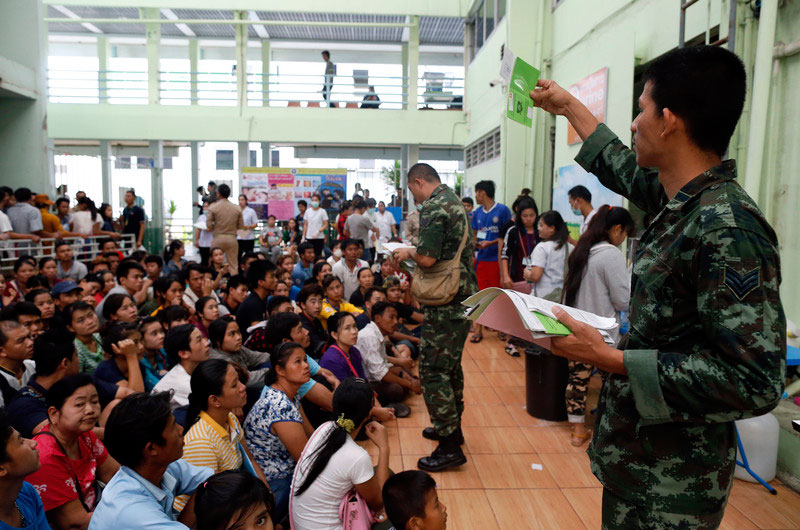 Thai soldiers check documents of migrant worker documents during a March 2018 registration event in Samut Sakhon. Photo: EPA-EFE/Rungroj Yongri