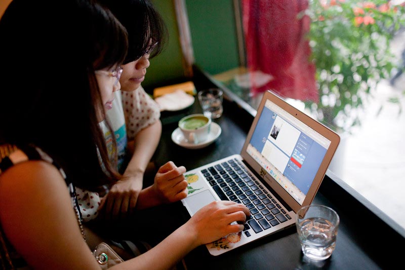 Women browse social networking site Tumblr in a café in Hanoi in September 2013. Photo: EPA/Luong Thai Linh