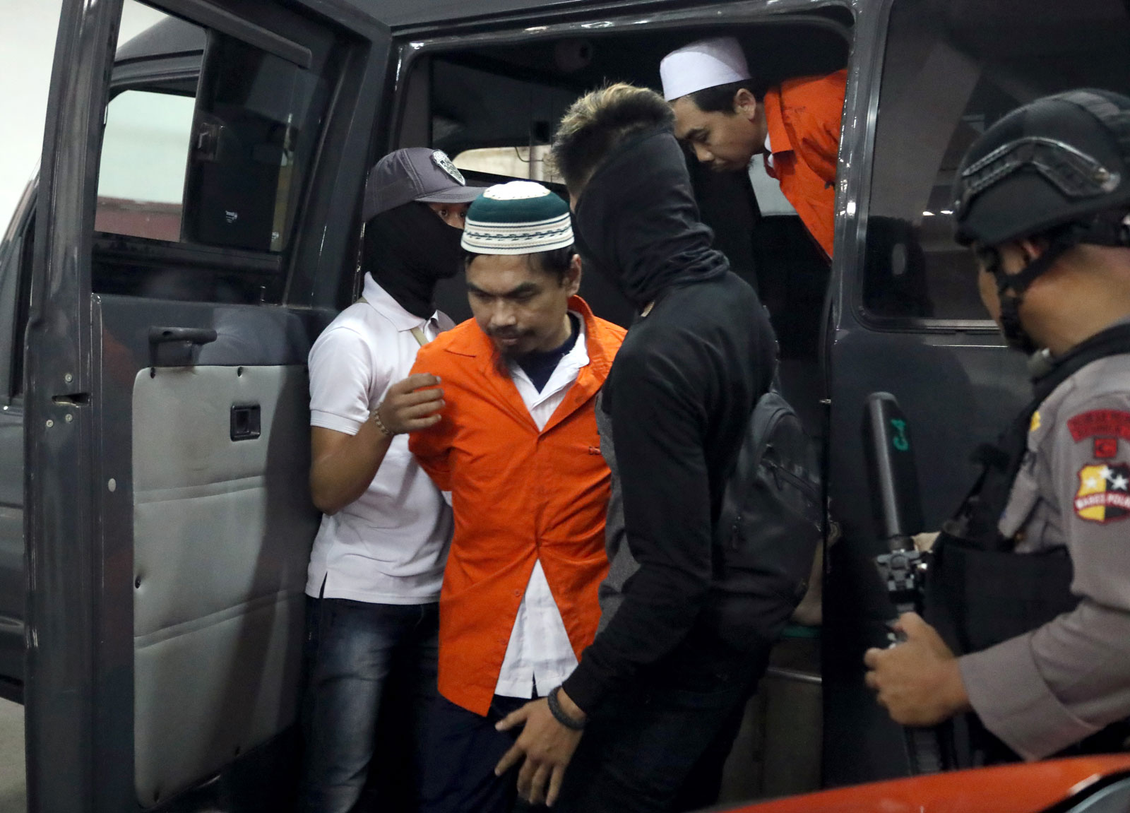 Indonesian member of the Jamaah Ansharut Daulah terrorist group, reportedly affiliated to ISIS, Wawan Kurniawan (C), 43, is escorted to his trial in Jakarta in September 2018. Photo: EPA-EFE/Bagus Indahono